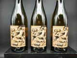 trois bouteilles de vin posées sur un bloc de bois