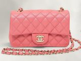 un sac Chanel rose avec une bandoulière en chaîne sur fond blanc