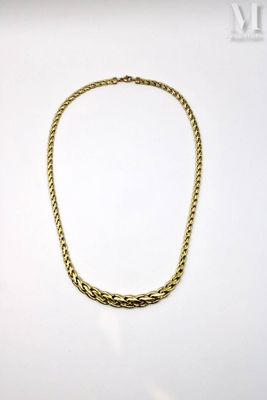 a gold necklace on a white surface with a white background
