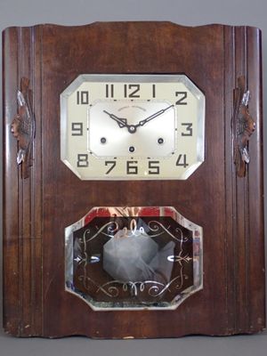 une horloge accrochée au mur, avec un oiseau à l'intérieur