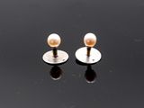 paire de boucles d'oreilles à clous en perles sur fond noir avec reflets