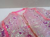 a pink dress with sequins on it on a table