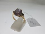 une image représentant une bague en or sertie d'une pierre violette