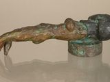 a bronze statue of a person laying on a table