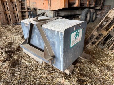 une boîte métallique posée au milieu d'un tas de foin