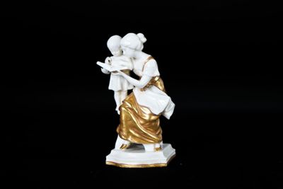 figurine représentant une femme tenant un enfant dans ses bras, sur fond noir