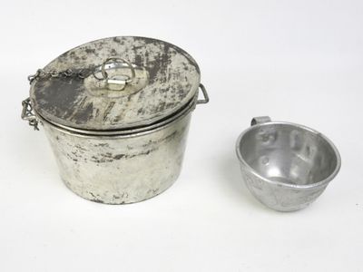 une théière en argent et une tasse en argent posées sur un plan de travail blanc