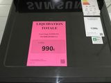 a black television with a pink sticker on it