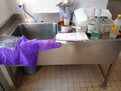 un évier de cuisine avec des bouteilles et encore des bouteilles sur le plan de travail