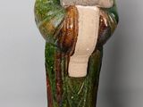 a figurine of a man holding a book