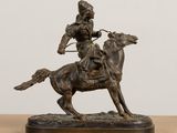 bronze statue of a man on a horse with a bow and arrow