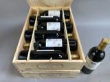 six bottles of wine in a wooden box next to a bottle of wine