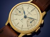 a close up of a gold wrist watch with a brown leather strap