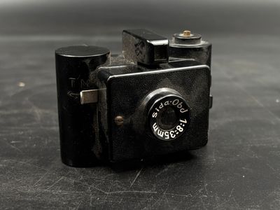 a small black camera sitting on a black surface