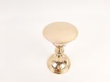 a small gold candle holder on a white surface