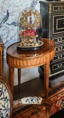une petite table sur laquelle est posée une horloge, dans une pièce
