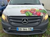 une camionnette blanche garée devant une remorque sur laquelle est accrochée une pancarte