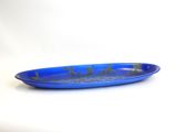 blue plate with gold design on it sitting on a white surface