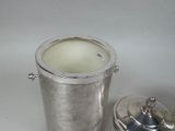 a silver ice bucket with a lid next to a silver container