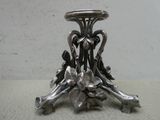 un bougeoir en argent posé sur une table ornée de fleurs