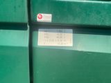 a close up of a green trash can with a sticker on it