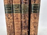 three old books sitting on top of each other on a white surface