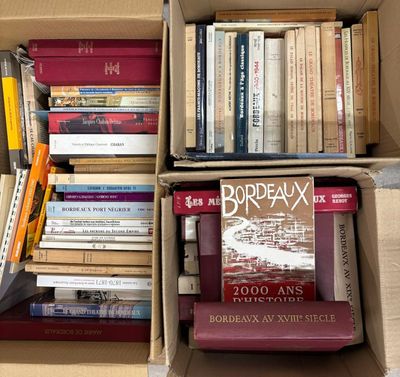 de nombreux livres qui se trouvent dans une boîte posée par terre
