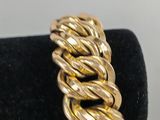 a close up of a gold bracelet on a black ring