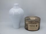 a picture of a white vase and a candle on a table