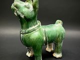 a green statue of a dog on a black background
