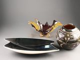 two bowls and a vase sitting on a table