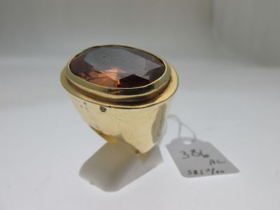 une image représentant une bague en or sertie d'une pierre brune