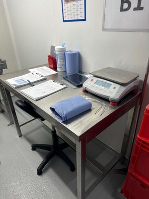 un bureau sur lequel se trouvent un ordinateur portable, une imprimante et d'autres objets