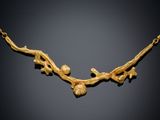a close up of a gold necklace on a black background