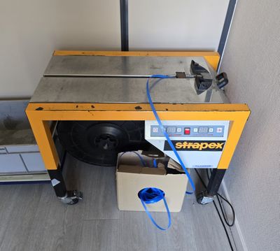 une machine posée sur le sol à côté d'une boîte