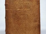 an old brown book with a design on the cover