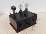une petite boîte noire surmontée de trois ampoules