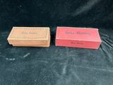 two boxes of soap sitting on top of a black cloth