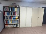 a room with a bookshelf and cabinets in it