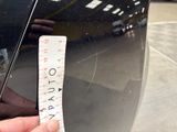a hand that is holding a sticker in front of a car