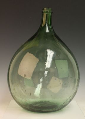 un vase en verre vert posé sur une table blanche