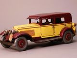 une petite voiture jaune et rouge sur fond gris