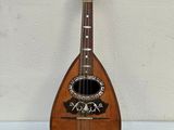 an old wooden mandolin sitting on top of a white table