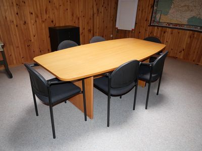 une table et des chaises dans une pièce où est accrochée une carte au mur