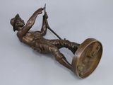 bronze statue of a boy on a swing with a clock