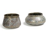deux vases en argent posés côte à côte sur une surface blanche