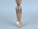une petite statue en bois représentant un garçon à la petite tête