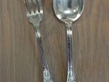 two silver spoons and a fork on a wooden table