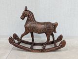 a wooden rocking horse that is sitting on the floor