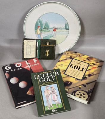 several books and a plate on a table with a plate in the background